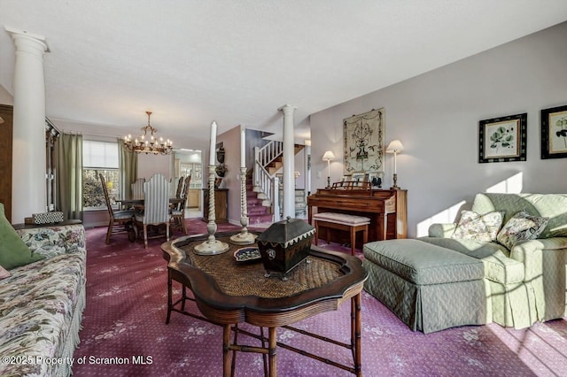 living area with a textured ceiling, stairs, dark colored carpet, decorative columns, and an inviting chandelier