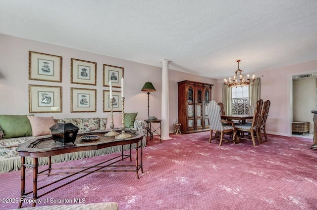 living area featuring a chandelier, a textured ceiling, carpet flooring, baseboards, and ornate columns