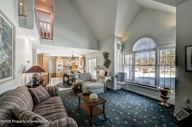 living room featuring carpet floors, high vaulted ceiling, and baseboards