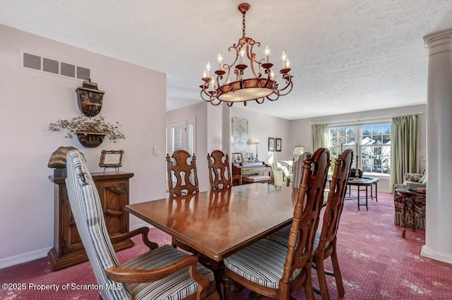 dining area featuring decorative columns, baseboards, visible vents, an inviting chandelier, and a textured ceiling