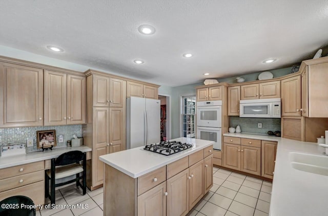 kitchen featuring white appliances, light countertops, a kitchen island, and light tile patterned floors