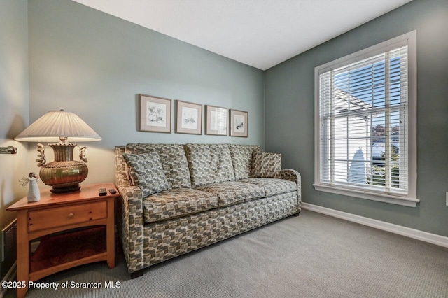 carpeted living area featuring baseboards