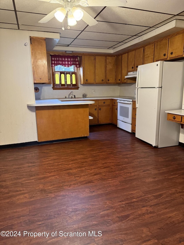 kitchen featuring ceiling fan, dark wood-type flooring, kitchen peninsula, white appliances, and a paneled ceiling