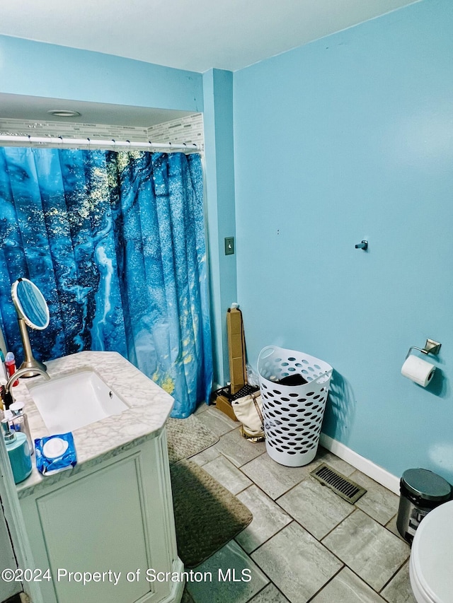 bathroom with tile patterned flooring, vanity, and toilet