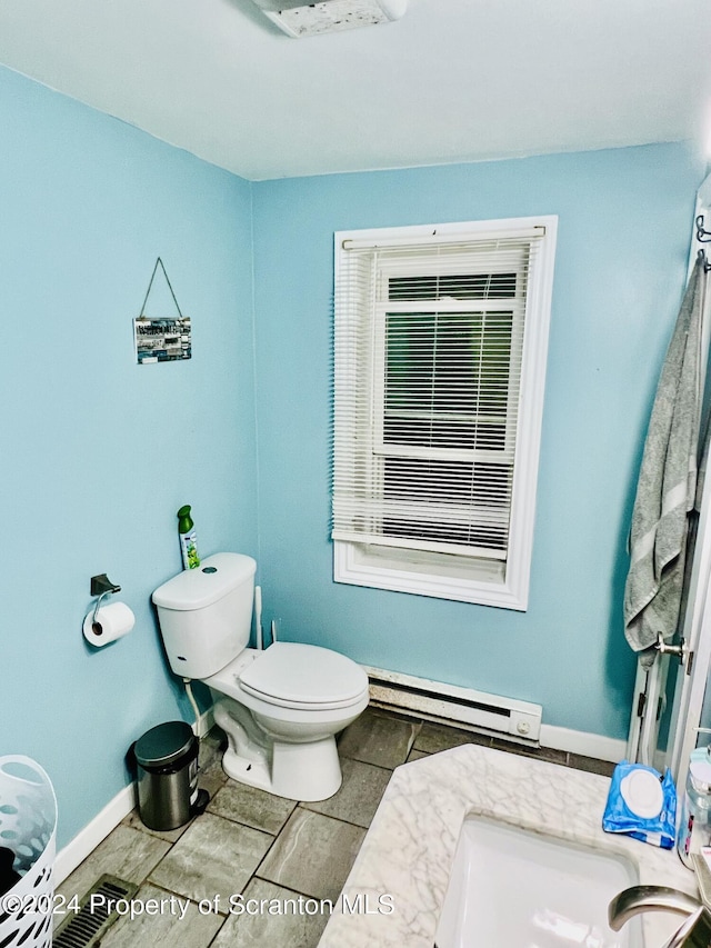 bathroom with tile patterned floors, toilet, and a baseboard radiator