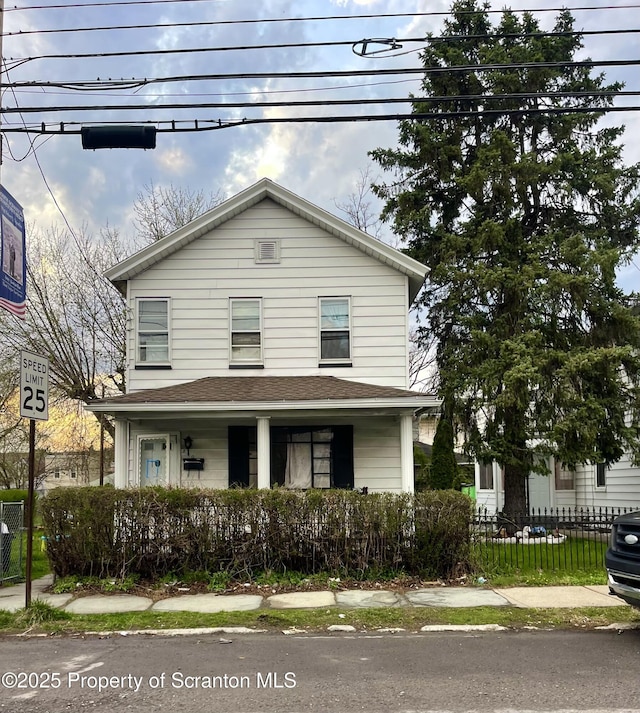 view of front of home with a porch and fence