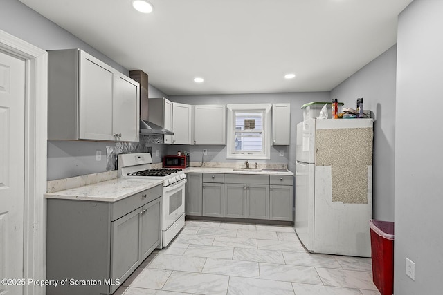 kitchen featuring wall chimney exhaust hood, a sink, gray cabinetry, white appliances, and marble finish floor