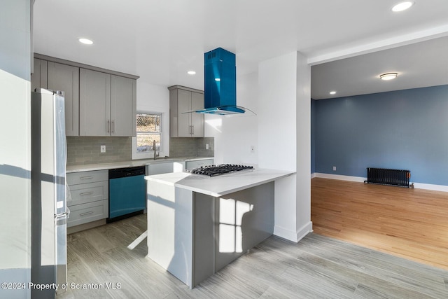 kitchen with a kitchen bar, appliances with stainless steel finishes, kitchen peninsula, extractor fan, and light hardwood / wood-style flooring