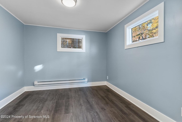 spare room featuring dark hardwood / wood-style floors, crown molding, and baseboard heating