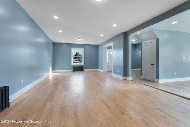 unfurnished living room featuring light hardwood / wood-style floors and radiator