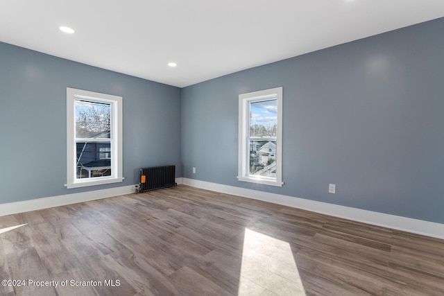 empty room with radiator and light hardwood / wood-style flooring