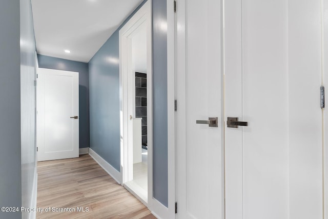 hallway with light hardwood / wood-style floors