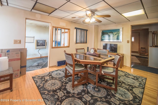 dining area featuring hardwood / wood-style flooring, a drop ceiling, and ceiling fan