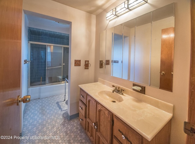 bathroom with vanity and combined bath / shower with glass door