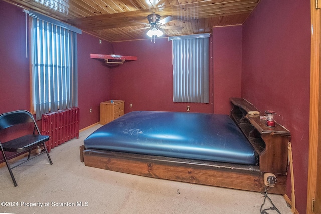 carpeted bedroom with ceiling fan, beamed ceiling, and wooden ceiling