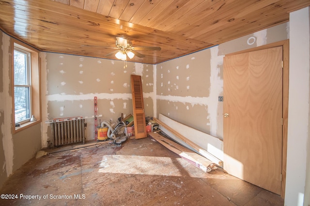 empty room with ceiling fan, wooden ceiling, and radiator