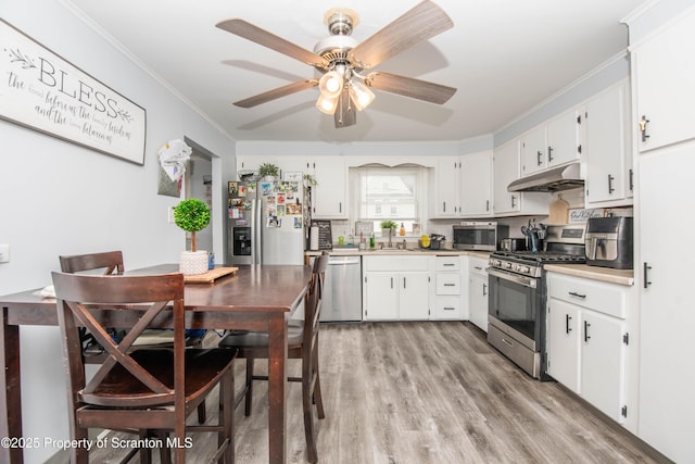 kitchen with white cabinetry, sink, stainless steel appliances, and light hardwood / wood-style floors