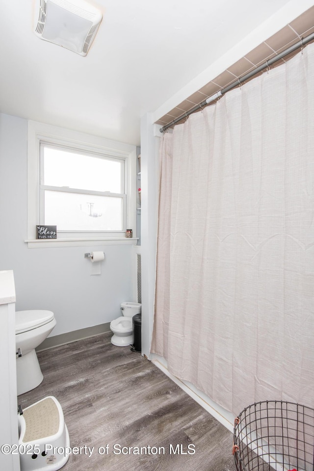 bathroom with wood-type flooring and toilet