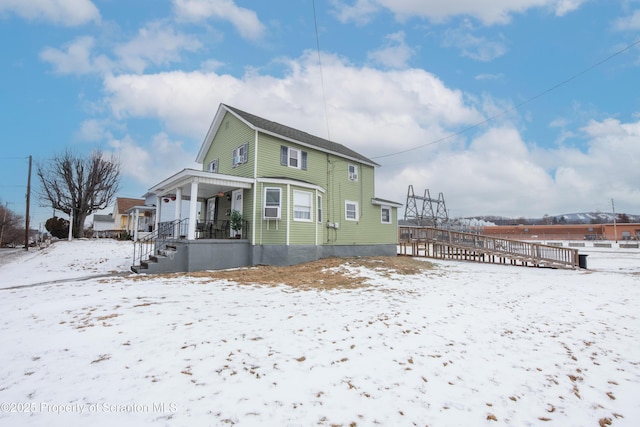 snow covered property featuring a porch