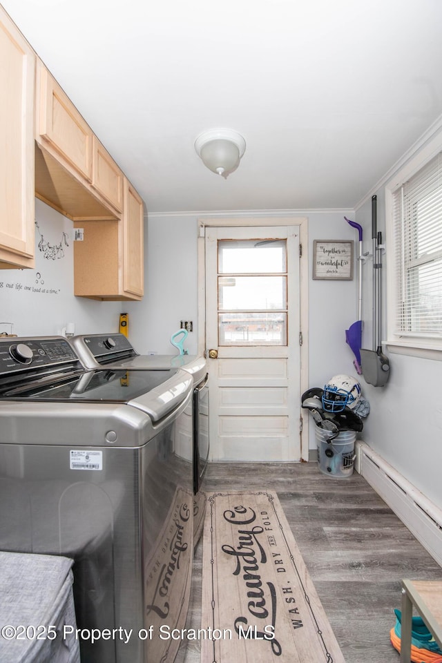 laundry room with hardwood / wood-style flooring, crown molding, cabinets, separate washer and dryer, and a baseboard radiator