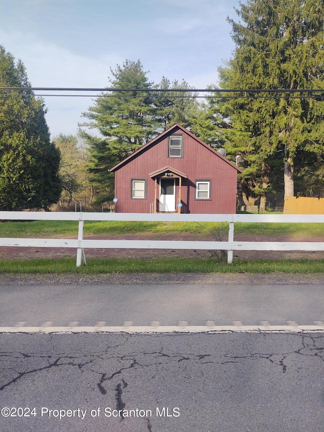 view of front of property featuring an outdoor structure and a front yard