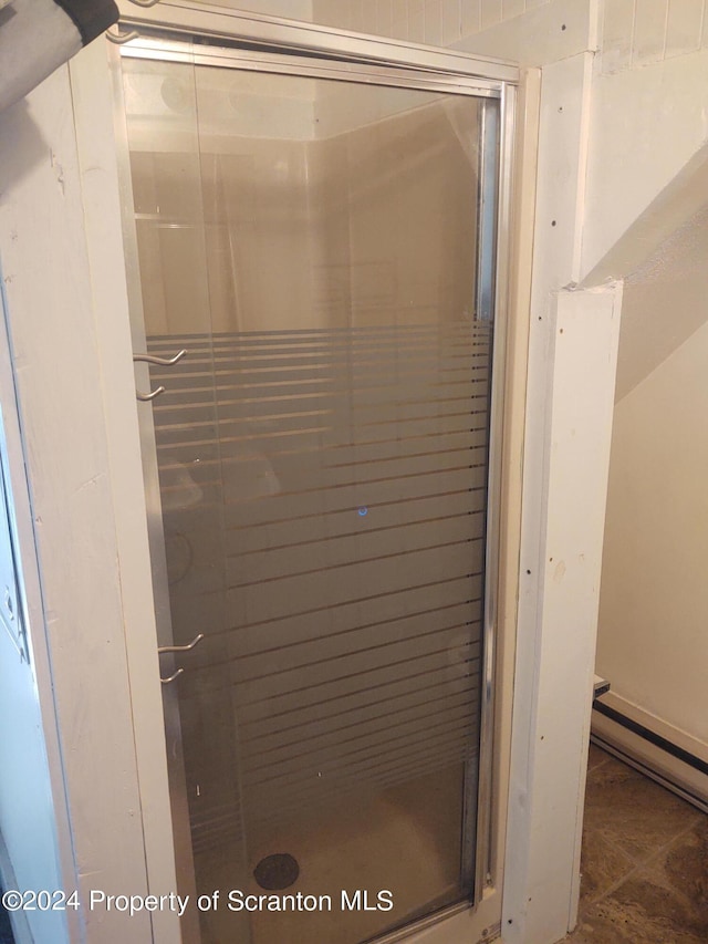 bathroom with tile patterned flooring and a shower with door