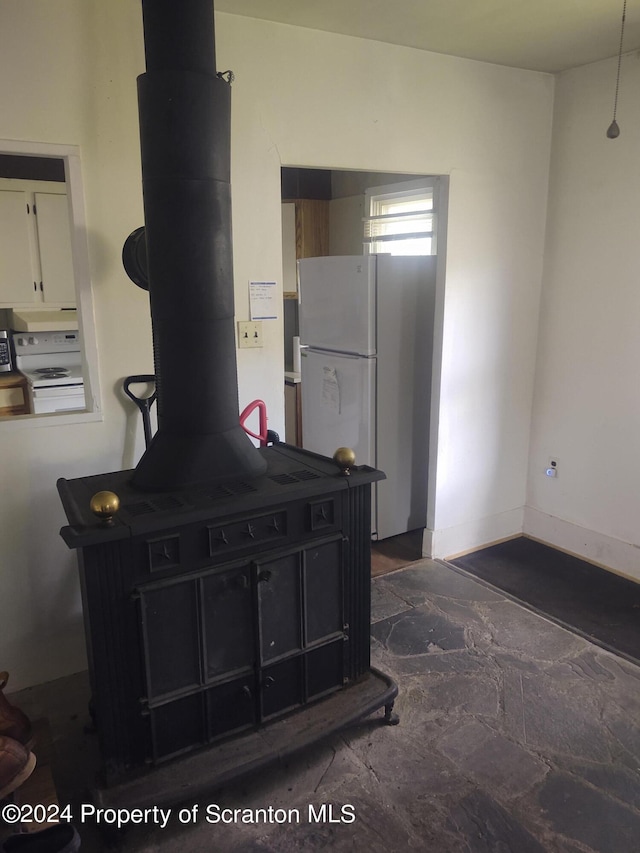 kitchen featuring stove, white cabinets, and white refrigerator