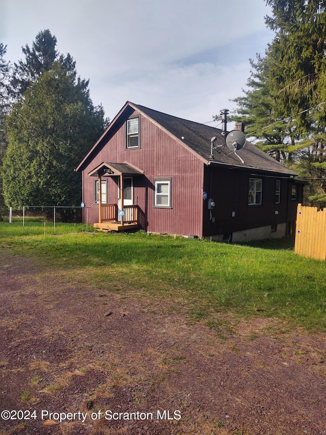 rear view of property featuring a yard