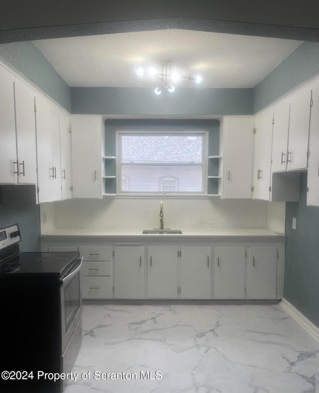 kitchen featuring tasteful backsplash, white range with electric cooktop, white cabinetry, and sink