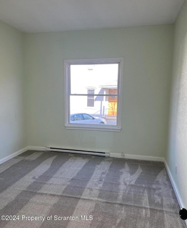 carpeted spare room featuring a baseboard radiator