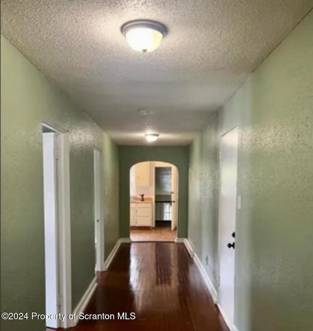 corridor featuring hardwood / wood-style flooring and a textured ceiling