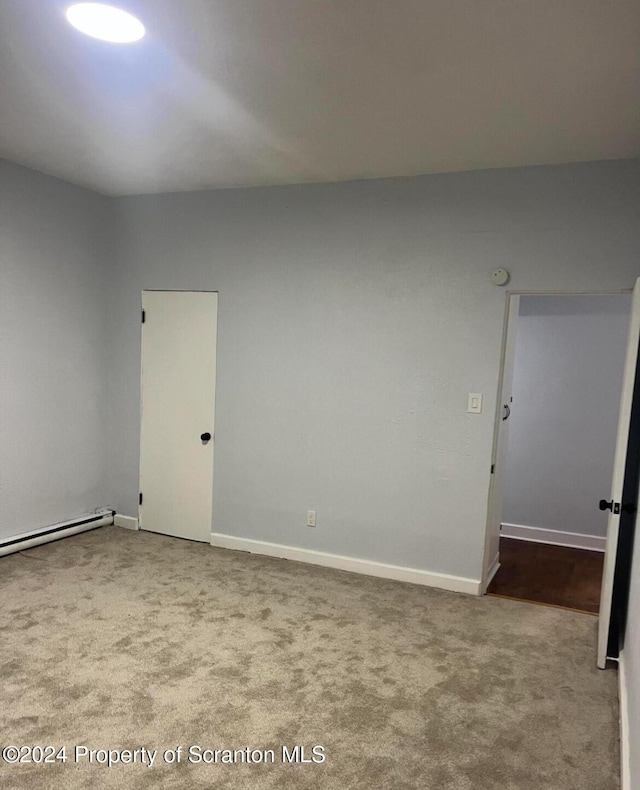 carpeted empty room featuring a baseboard radiator