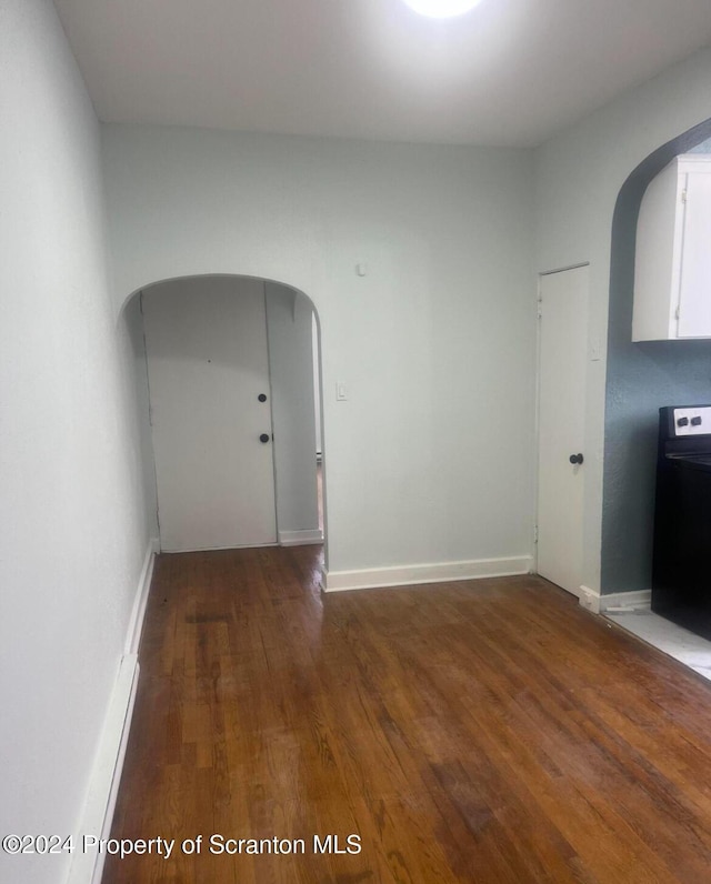 empty room with dark hardwood / wood-style flooring