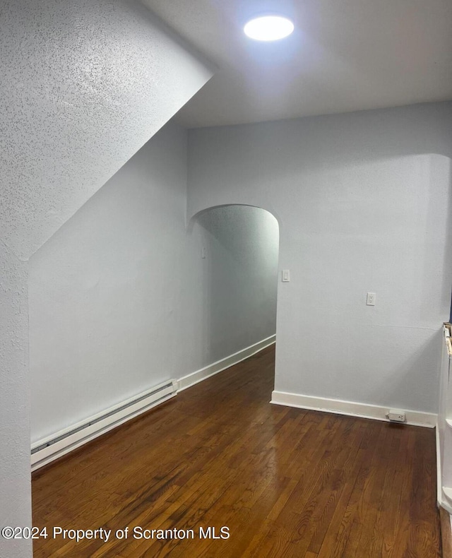 bonus room featuring dark wood-type flooring and a baseboard radiator