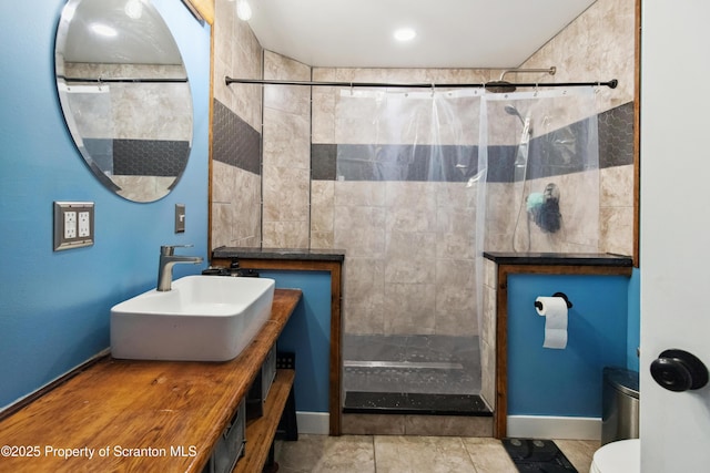 full bathroom with toilet, vanity, and tiled shower