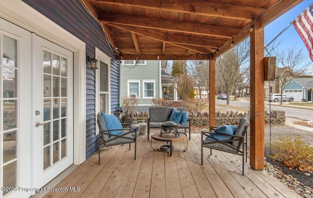 wooden terrace with french doors and an outdoor living space