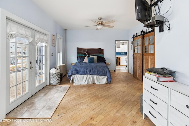 bedroom featuring light wood-type flooring, access to outside, multiple windows, and french doors