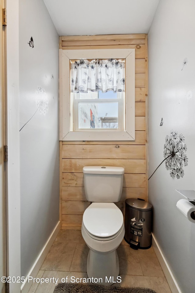 bathroom with tile patterned floors, baseboards, and toilet