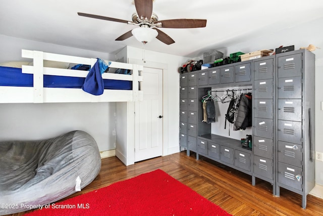 bedroom featuring wood finished floors, a ceiling fan, and baseboards