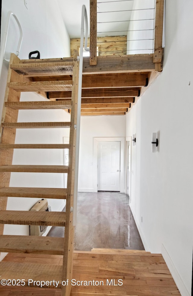 staircase featuring baseboards and wood finished floors