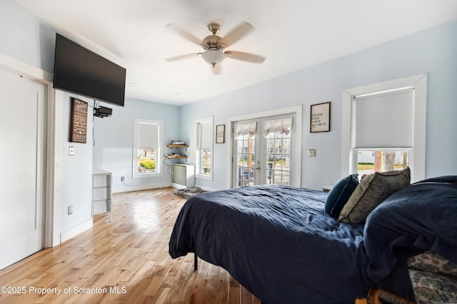bedroom with light wood-style floors, a ceiling fan, baseboards, and access to outside