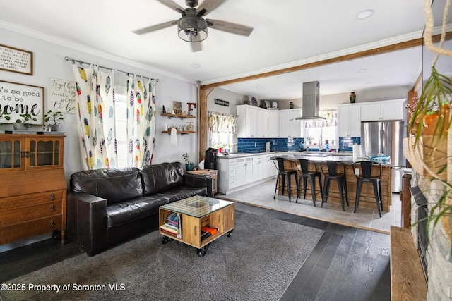 living room featuring dark wood-type flooring, crown molding, ceiling fan, and recessed lighting