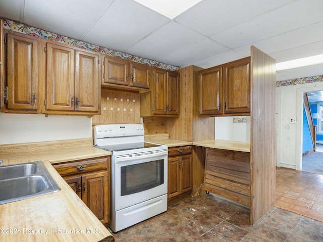 kitchen featuring a paneled ceiling, sink, and white range with electric stovetop