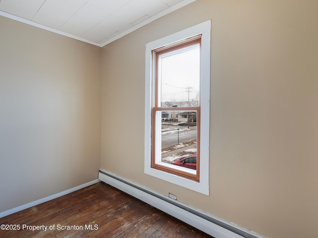 empty room with dark wood-type flooring, ornamental molding, and baseboard heating