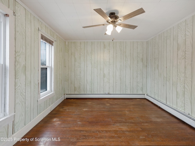 empty room with baseboard heating, ceiling fan, and dark hardwood / wood-style flooring