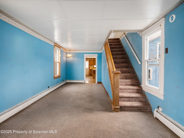 unfurnished living room featuring baseboard heating and carpet floors