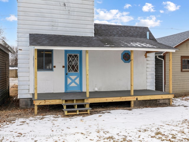 snow covered property entrance featuring covered porch