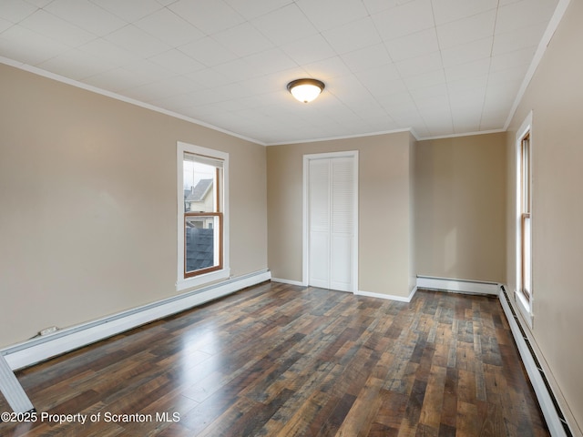 spare room with baseboard heating and dark wood-type flooring