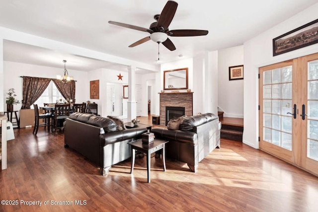 living room featuring decorative columns, wood-type flooring, ceiling fan, and french doors