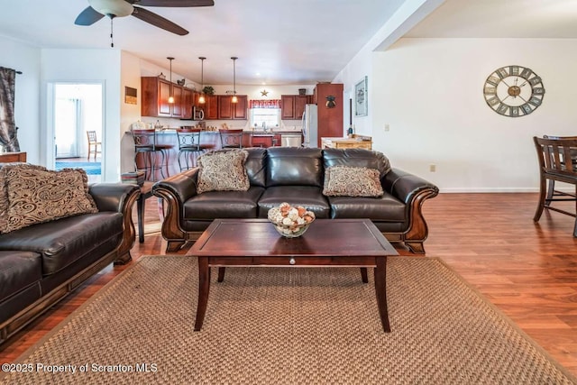 living room with ceiling fan, wood-type flooring, and sink